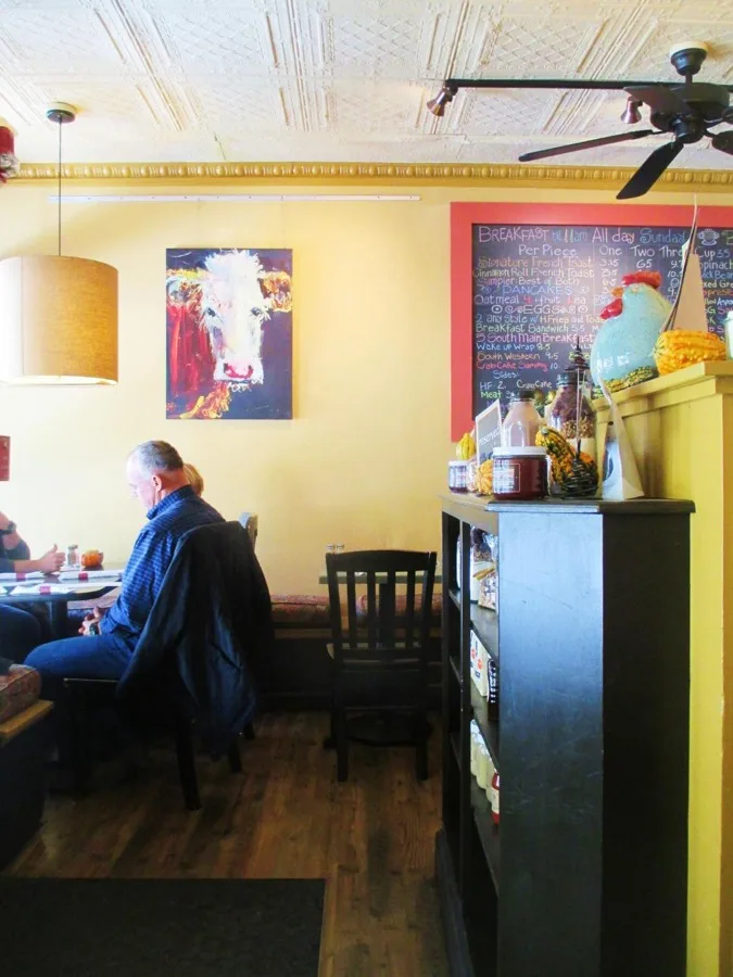 Cozy dining room at 5 South Main with tin ceiling and local artwork